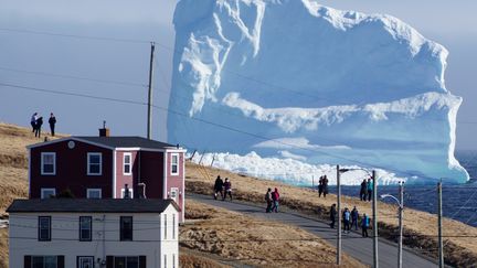 Des habitants de Ferryland (Canada) observent le premier iceberg de la saison passer près des côtes, le 16 avril 2017. Avec le réchauffement des eaux arctiques, ces icebergs fondent plus tôt et finissent par être beaucoup plus petits qu'auparavant. (JODY MARTIN / REUTERS)