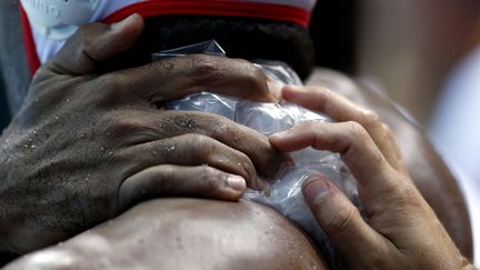 Les mains de l'espagnol Ivan Perez Vargas, &agrave; gauche, et Mario Garcia Rodgriguez qui tient un sac de glace sur les &eacute;paules de son co&eacute;quipier au cours du match contre l'Australie, jeudi 2 ao&ucirc;t 2012 aux JO de&nbsp;Londres. (JULIO CORTEZ / SIPA )