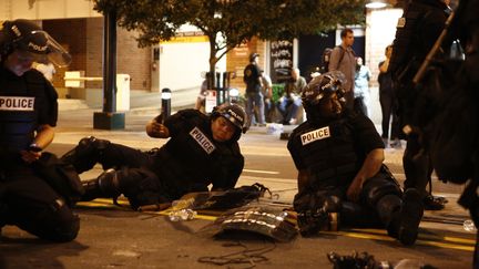 Ils ne protestent pas, mais se reposent. Ces policiers s'accordent une pause au milieu de la nuit.&nbsp; (BRIAN BLANCO / GETTY IMAGES NORTH AMERICA)