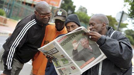 Des habitants de Soweto (Afrique du Sud) lisent un journal consacr&eacute; &agrave; la mort de Mandela, le 6 d&eacute;cembre 2013. (REUTERS)