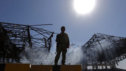 Un combattant&nbsp;Houthi&nbsp;sur le lieu d'une attaque aérienne, le 5 novembre 2017 à Sanaa, au Yemen.&nbsp; (MOHAMMED HUWAIS / AFP)