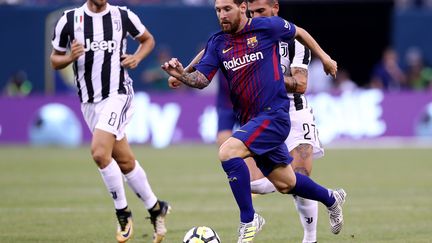 Le Barcelonais Lionel Messi poursuivi par les joueurs de la Juventus Turin. (ELSA / GETTY IMAGES NORTH AMERICA)