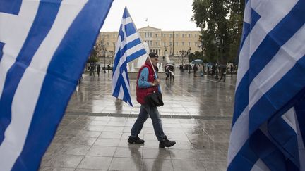 Un homme tient un drapeau grec pr&egrave;s du Parlement, le 24 janvier 2015 &agrave; Ath&egrave;nes. (MARKO DJURICA / REUTERS)