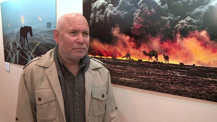 Steve McCurry devant la photographie des chameaux durant la guerre du Golfe en 1991 (France 3 Champagne-Ardenne)