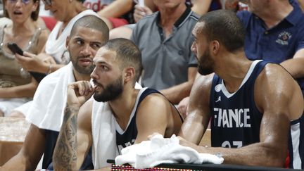 Nicolas Batum (Charlotte Hornets), Evan Fournier (Orlando Magic) et Rudy Gobert (Utah Jazz) (de gauche à droite) sur le banc de l'équipe de France lors d'un match de préparation contre l'Argentine, le 17 août 2019 à Villeurbanne (Rhône). (ROMAIN BIARD / AFP)