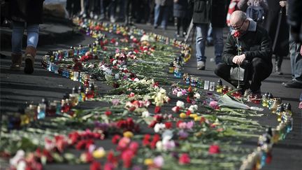 Des manifestants d&eacute;posent des fleurs et des bougies &agrave; proximit&eacute; des barricades &agrave; Kiev (Ukraine), le 24 f&eacute;vrier 2014. (LOUISA GOULIAMAKI / AFP)