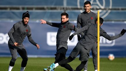 Lionel Messi se bat pour le ballon avec Angel Di Maria à côté Neymar lors d'une séance d'entraînement au Camp des Loges du PSG à Saint-Germain-en-Laye, le 14 février 2022. (FRANCK FIFE / AFP)