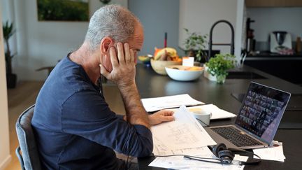 Un homme en télétravail devant son ordinateur pendant une visioconférence, le 2 janvier 2022.&nbsp; (VANESSA MEYER / MAXPPP)