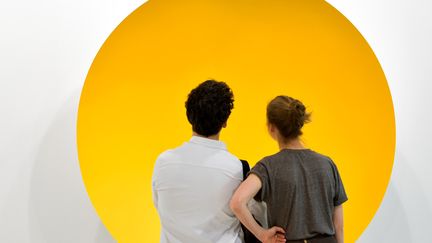 Un couple contemple le "Monochrome Yellow" (2017) de l'artiste britannique Anish Kapoor avant l'ouverture au public de l'Art Basel de Bâle. 
 (Fabrice COFFRINI / AFP)