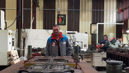 Laurent Malochet délégué CGT, travaille depuis 27 ans au sein de l'atelier outillage de GM&amp;S. Il pose&nbsp;derrière un outil "dupliqué" par PSA, selon lui, pour pouvoir se passer de son entreprise. (ISABELLE RAYMOND / RADIO FRANCE)