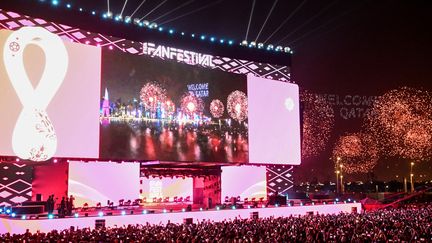 Des supporters regardent devant un écran géant à Doha des feux d'artifice avant le début de la Coupe du monde 2022, le 19 novembre 2022. (KIRILL KUDRYAVTSEV / AFP)