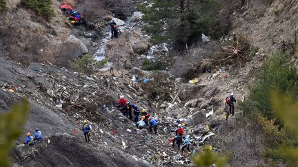 Des enqu&ecirc;teurs fouillent le site du crash de l'avion de Germanwings, dans les montagnes proches de Seyne (Alpes-de-Haute-Provence), le 26 mars 2015. (ANNE-CHRISTINE POUJOULAT / AFP)