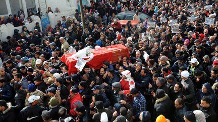 Des milliers de Tunisiens accompagnent le cercueil de l'opposant assassin&eacute;, Chokri Bela&iuml;d lors de ses fun&eacute;railles dans&nbsp;la banlieue sud de Tunis (Tunisie), le 8 f&eacute;vrier 2013. (FETHI BELAID / AFP)