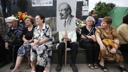 Des manifestants sont assis au pied d'une statue de L&eacute;nine lors d'une marche de protestation contre l'arm&eacute;e ukrainienne &agrave; Donetsk (Ukraine), le 6 juillet 2014. (MAXIM ZMEYEV / REUTERS)