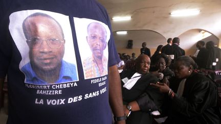 Un homme, arborant un T-shirt avec les portraits des défenseurs des droits&nbsp;de l'Homme Floribert Chebeya et Fidele Bazane, assiste au procès des policiers accusés du meurtre à Kinshasa, le 30 avril 2013. (AFP PHOTO / JUNIOR D. KANNAH)