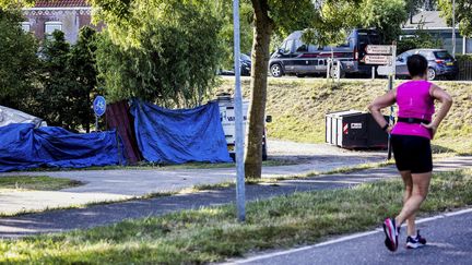 Des bâches bleues couvrent, le 28 août 2022, le lieu où un camion a renversé la veille des participants à un barbecue, tuant six personnes, à&nbsp;Zuidzijdsedijk (Pays-Bas). (JEFFREY GROENEWEG / ANP MAG / AFP)