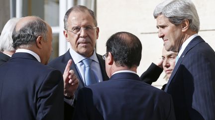 De gauche &agrave; droite : Laurent Fabius (de dos), son homologue russe Sergue&iuml; Lavrov, Fran&ccedil;ois Hollande (de dos) et John Kerry, secr&eacute;taire d'Etat am&eacute;ricain, le 5 mars 2014 &agrave; l'Elys&eacute;e. (ALAIN JOCARD / AFP)