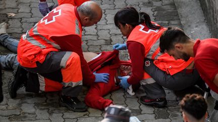 Un blessé reçoit des soins médicaux lors d'une course de taureaux (encierro)&nbsp; à Pampelune (Espagne), le 9 juillet 2022. (MIGUEL RIOPA / AFP)