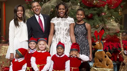 Le pr&eacute;sident am&eacute;ricain Barack Obama, entour&eacute; de son &eacute;pouse Michelle et de leurs filles Sasha et Malia, lors d'une c&eacute;l&eacute;bration de No&euml;l dans un h&ocirc;pital de Washington (Etats-Unis), le 15 d&eacute;cembre 2013. (SAUL LOEB / AFP)