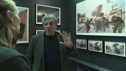 Patrick Chavel devant une photo prise à Mossoul en 2016 alors qu'il accompagne son fils Antoine sur le terrain. Mémorial de Caen. (C. Lefrançois / France Télévisions)