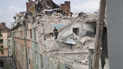 Un secouriste inspecte les décombres d'un immeuble touché par une frappe russe, le 6 juillet 2023, à Lviv (Ukraine). (SERVICES DE SECOURS UKRAINIENS / AFP)