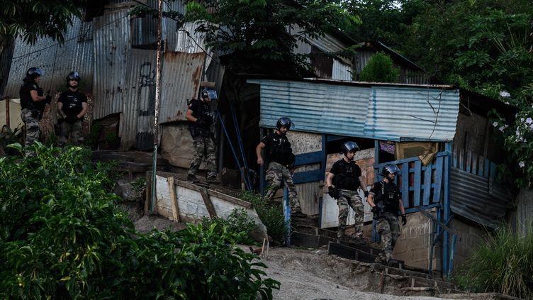 Gendarmes monitor the destruction of the Talus 2 slum, in Mayotte, on May 22, 2023. (PHILIPPE LOPEZ / AFP)