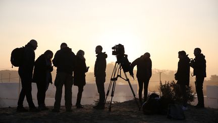 Des journalistes regroupés à l'aube du deuxième jour du démantèlement de la "jungle", mardi 25 octobre 2016. Plus de 700 journalistes se sont accrédités pour couvrir cette évacuation, selon la&nbsp;préfecture du Pas-de-Calais. (NEIL HALL / REUTERS)