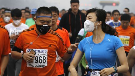 Des coureurs participent au marathon de P&eacute;kin (Chine) en portant des masques anti-pollution, le 19 octobre 2014. (ANDY WONG / AP / SIPA)