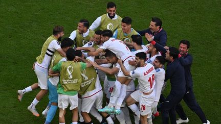 L'équipe de football iranienne célèbre sa victoire contre le pays de Galles lors des phases de groupe de la Coupe du monde, le 25 novembre 2022, à Doha (Qatar). (ANTONIN THUILLIER / AFP)