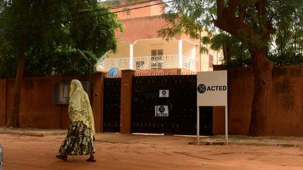 Une femme marchant devant les portes du siège de l'ONG Acted à Niamey, au Niger, le 10 août 2020.&nbsp; (BOUREIMA HAMA / AFP)