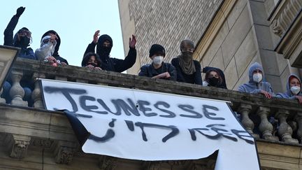 Des étudiants&nbsp;déploient une banderole à l'université Paris-Sorbonne le 14 avril 2022. (EMMANUEL DUNAND / AFP)