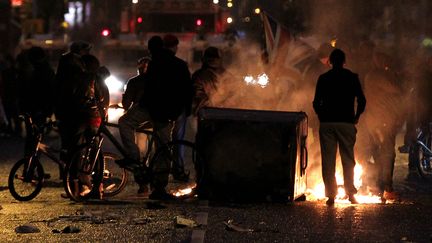 Des protestants brandissent&nbsp;l'Union Jack au milieu des d&eacute;bris dans les rues de Belfast, en Irlande du Nord, samedi 5 janvier 2013. (PETER MUHLY / AFP)