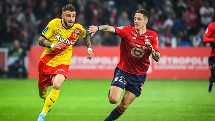 Jonathan Clauss (gauche) et Domagoj Bradaric (droite) au duel lors de Lille-Lens en Ligue 1 le 16 avril 2022. (MATTHIEU MIRVILLE / DPPI via AFP)