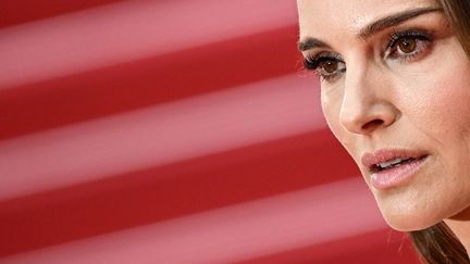 L'actrice Natalie Portman, concentrée, lance un regard perçant aux nombreux photographes. Elle remontera les marches samedi soir pour présenter le nouveau film de Todd Haynes "May December", en compétition officielle, dans lequel elle a le premier rôle. (LOIC VENANCE / AFP)