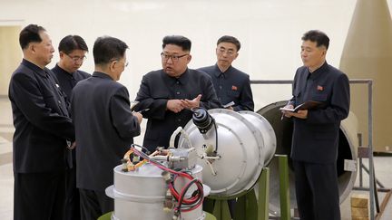 Le leader nord-coréen, Kim Jong-un, devant la charge d'un missile démonté, sur un cliché diffusé le 3 septembre 2017. (KCNA VIA KNS / AFP)