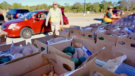 Des bénévoles de la Banque alimentaire du centre du Texas chargent des colis dans une voiture, le 25 octobre 2022, lors d'une distribution à Austin. (MARIE-VIOLETTE BERNARD / FRANCEINFO)