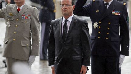 Et c'est un pr&eacute;sident tremp&eacute; jusqu'aux os qui a rendu hommage au soldat inconnu sous l'Arc de Triomphe. (REGIS DUVIGNAU / REUTERS)