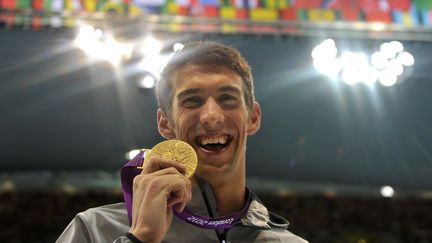 Michael Phelps avec sa médaille d'or sur 100m papillon à Londres en 2012. (CHRISTOPHE SIMON / AFP)