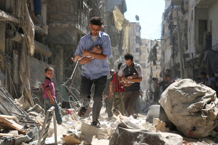 Pères syriens transportant leurs enfants dans les ruines d'Alep
 (Ameer Alhalbi/ AFP)