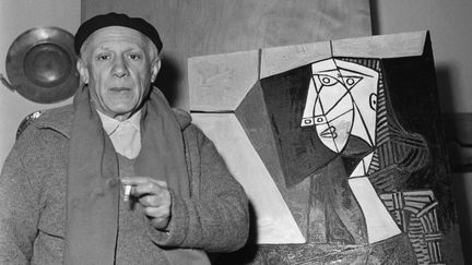 Pablo Picasso devant la peinture "Femme assise en costume vert", à Vallauris (Alpes-Maritimes), en 1953. (BETTMANN / GETTY IMAGES)