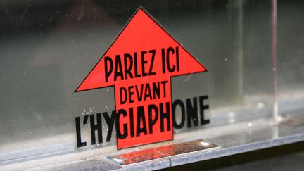 Auto-collant à un guichet vitré indiquant "Parlez ici devant l'hygiaphone". (CATHERINE GRAIN / RADIOFRANCE)