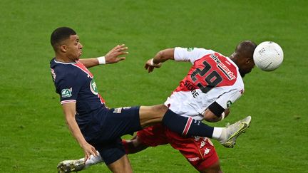 L'attaquant du PSG Kylian Mbappé à la lutte avec le défenseur monégasque Djibril Sidibé en finale de la Coupe de France, mercredi 19 mai 2021 au Stade de France (Seine-Saint-Denis). (ANNE-CHRISTINE POUJOULAT / AFP)