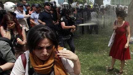 Un policier turc envoie du gaz lacrymog&egrave;ne sur une jeune femme, place Taksim, &agrave; Istanbul (Turquie), le 28 mai 2013. (OSMAN ORSAL / REUTERS)