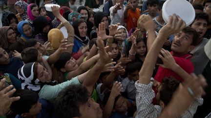 Il faut alors compter sur les rations de nourriture comme ces migrants afghans dans le camp de la Moria au Sud de l'ile grecque de Lesbos le 22 ao&ucirc;t 2015.&nbsp; (VISAR KRYEZIU/AP/SIPA)