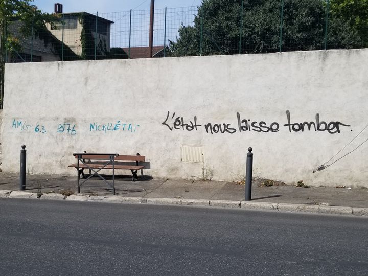 Des tags sur un mur qui fait face à l'entrée de la cité des Marronniers, dans le 14e arrondissement de Marseille, le 25 août 2021. (CLEMENTINE VERGNAUD / RADIO FRANCE)