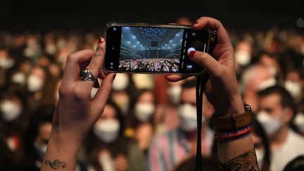 Un spectateur prend une photo avant le début du concert-test au Palau Sant Jordi de Barcelone, le 27 mars 2021. (LLUIS GENE / AFP)