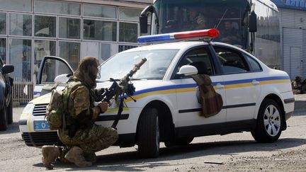 Un soldat ukrainien se prot&egrave;ge des tirs pr&egrave;s d'un checkpoint, &agrave; Debaltseve, dans la r&eacute;gion de Donetsk (Ukraine), le 16 ao&ucirc;t 2014. (ANATOLII STEPANOV / AFP)