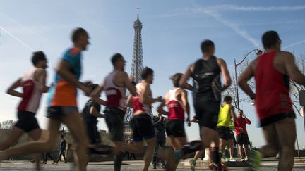 Des coureurs en plein effort près de la tour Eiffel, lors du Marathon de Paris, le 12 avril 2015. (VALERIY MELNIKOV / RIA NOVOSTI / AFP)