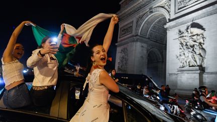 Des supportrices de l'Algérie brandissent un drapeau sur la place de l'Etoile à Paris, après la victoire algérienne en finale de la CAN, le 19 juillet 2019. (BERTRAND GUAY / AFP)