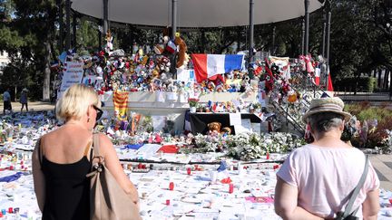 Deux personnes se recueillent devant un mémorial improvisé en souvenir des victimes de l'attentat de Nice, le 19 juillet 2016 à Nice. (VALERY HACHE / AFP)